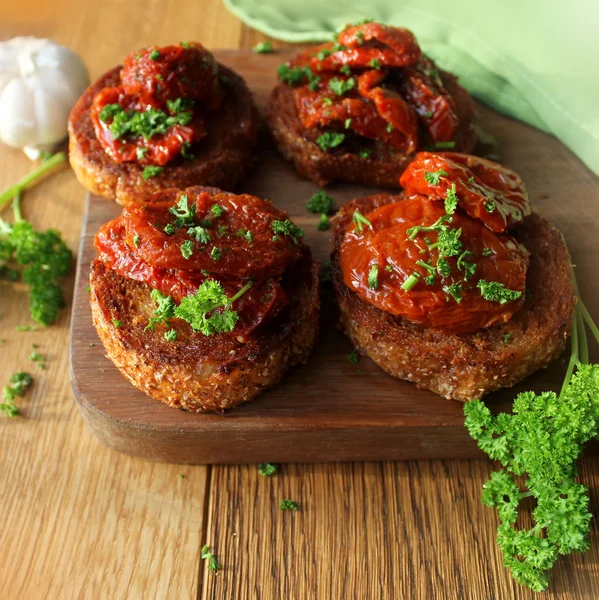 Bruschetta met olijfolie, zongedroogde tomaten, peterselie — Stockfoto