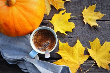 Sonbahar arkaplanı. Bulanık sonbahar yaprakları ve bir fincan sıcak kahveyle kabak arkaplanı.