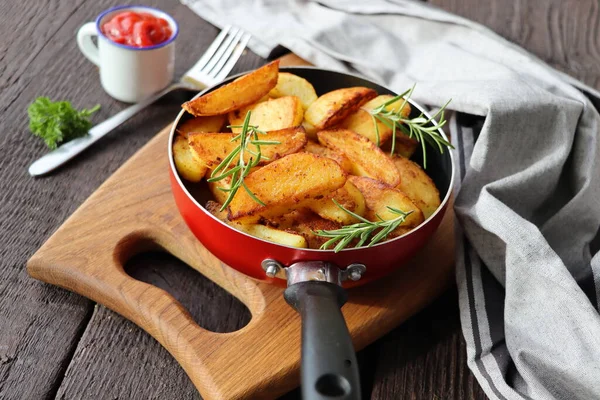Fried potatoes with rosemary in iron pan — Stock Photo, Image