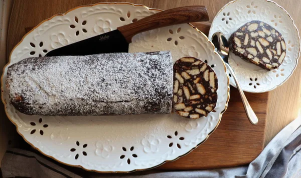 Bolo preguiçoso ou bolo de mosaico. Caseiro não assar bolo de biscoito de chocolate em uma mesa de madeira — Fotografia de Stock