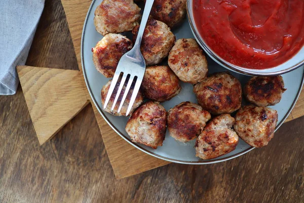 Roasted meatballs with tomato sauce , delicious meat cutlets on wooden table. Top view — Stock Photo, Image