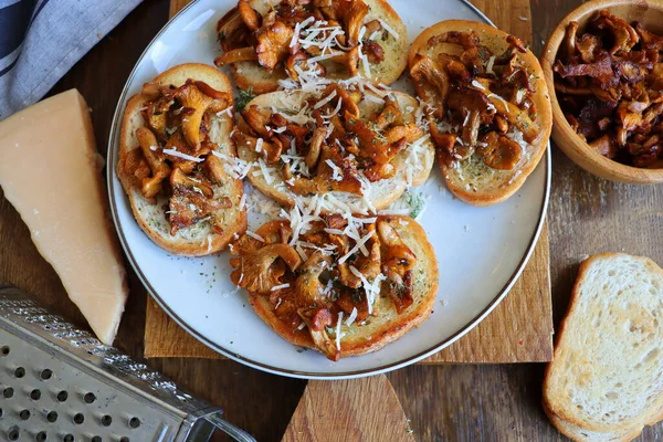 Chanterelle sandwiches with cheese. Open faced sandwich with creamy , seasonings and pepper and herbs on an old wooden background. Mock up. Top view — Foto de Stock