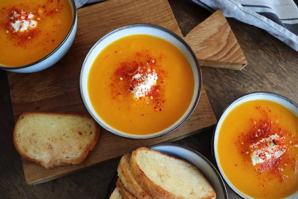 Soupe crémeuse à la citrouille fraîche pour le dîner d'automne sur table rustique — Photo