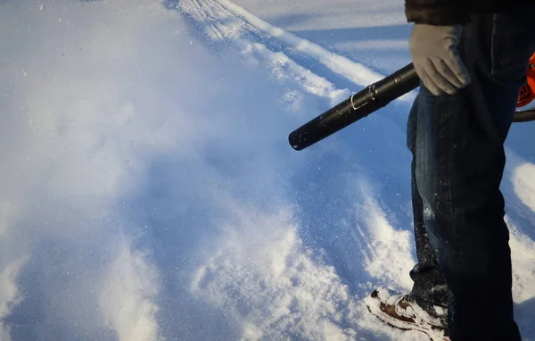 De mens reinigt bestrating van sneeuw met blazer — Stockfoto