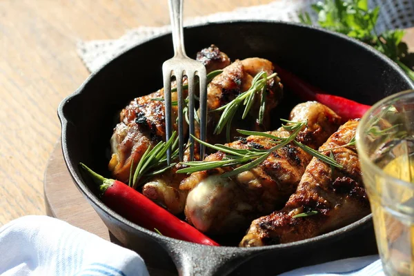 나무 식탁에 구운 닭고기로 만든 남비와 포도주 잔을 곁들인 프라이팬 과 함께 맛있는 식사를 하는 것에 대한 관념 — 스톡 사진