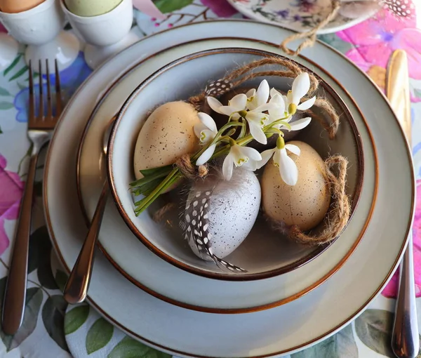 Stijlvolle paastafel met ei in kom op tafel. Modern natuurlijk geverfd paaseieren, bloemen op bord en bestek. Feestelijke tafeldecoraties met Pasen — Stockfoto