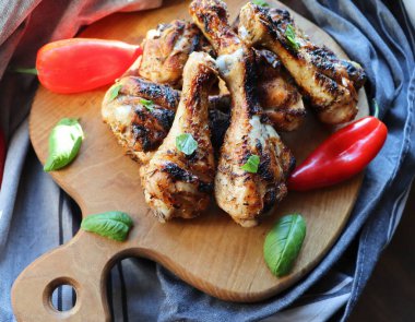 Izgara tavuk ayak kesme tahtası üzerinde. Rustik arka plan