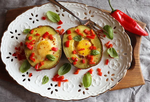 Keto diet. Healthy breakfast of baked avocado and eggs boats with herbs — Stock Photo, Image