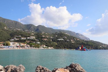 Korfu 'da Ipsos' ta güzel bir sahil, turistler kumsalda güzel bir yaz günü geçiriyorlar. Yunanistan.