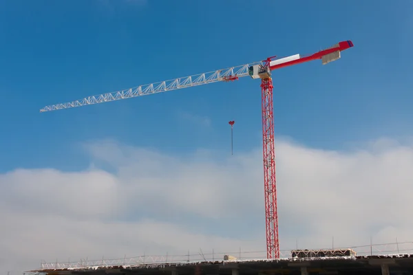 Costruzione gru alta rossa contro il cielo blu — Foto Stock