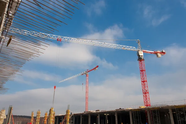 Costruzione gru bianche rosse contro il cielo blu — Foto Stock