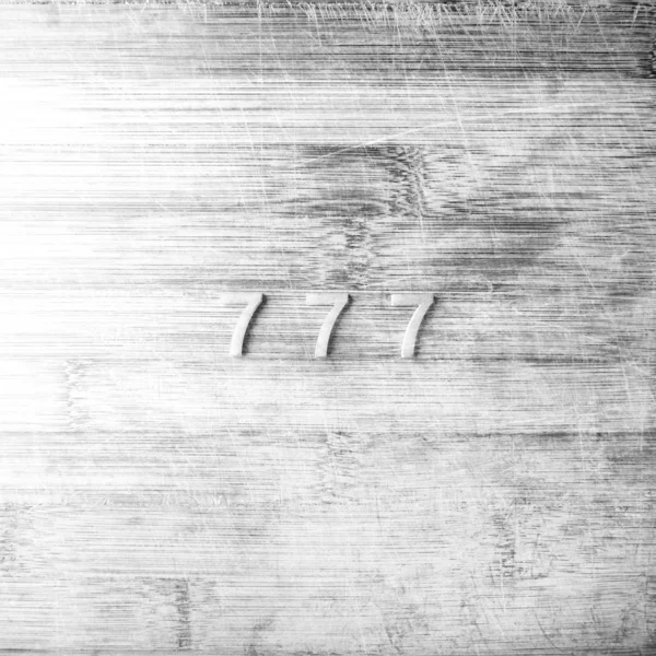 Tres sietes sobre un fondo de madera — Foto de Stock