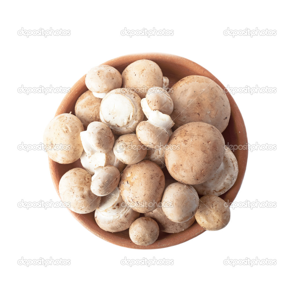 Fresh mushrooms in a bowl of clay isolated over white