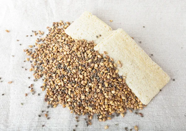 Trigo molido y cáñamo con pan crujiente de granos de maíz sobre el ensacado . — Foto de Stock