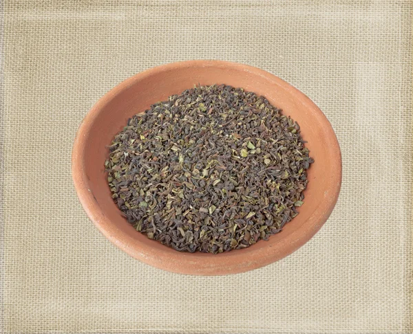 Mistura de chá verde e preto em tigela de argila isolada sobre fundo de ensacamento em estilo antigo — Fotografia de Stock