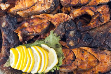 üzerine limon ve yeşil ile barbekü ızgara balık filetosu. Mangalda balık limon dilimleri ile dekore edilmiştir..