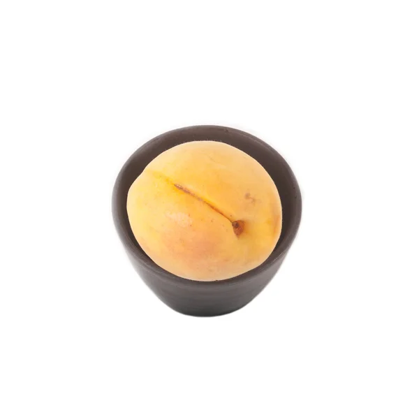 Rijp abrikozen in keramische cup geïsoleerd op witte achtergrond — Stockfoto