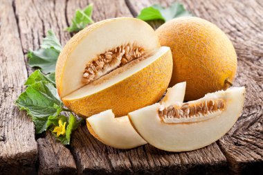 kavun dilimleri ve eski ahşap bir masa yapraklarda.