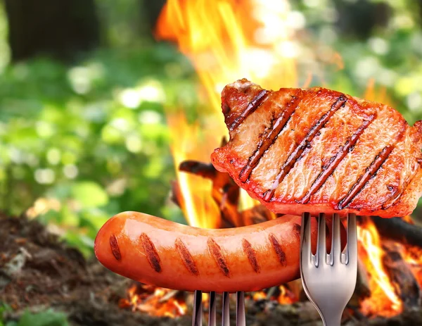 Salsicha e bife em um garfo . — Fotografia de Stock