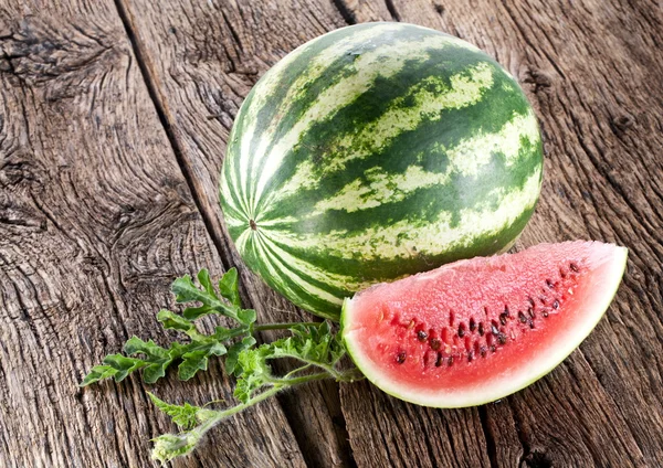 Vattenmelon med ett segment och blad — Stockfoto