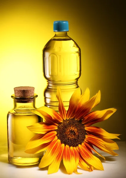 Cooking oil in a plastic and glass bottles with sunflower. — Stock Photo, Image