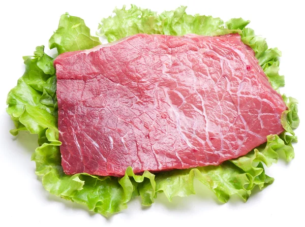 Obearbetat kött på salladsblad. — Stockfoto