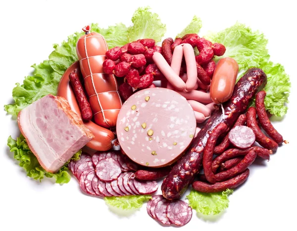 Meat and sausages on lettuce leaves. — Stock Photo, Image