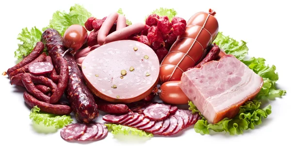 Meat and sausages on lettuce leaves. — Stock Photo, Image