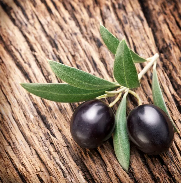Ripe black olives with leaves. — Stock Photo, Image