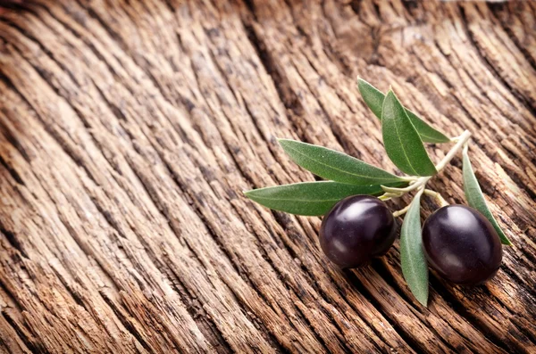 Reife schwarze Oliven mit Blättern. — Stockfoto