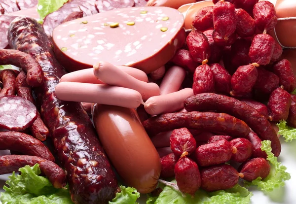 Carne y embutidos sobre hojas de lechuga . — Foto de Stock