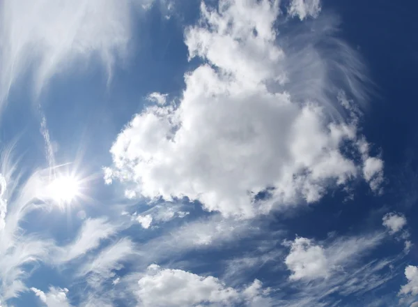 Cielo azul con nubes y sol. — Foto de Stock