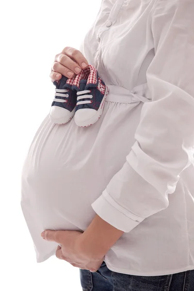 Mujer embarazada manteniendo zapatos de bebé . — Foto de Stock