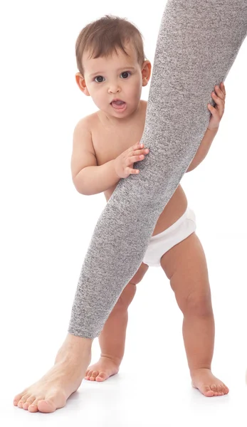 Baby holds on mum's leg. — Stock Photo, Image