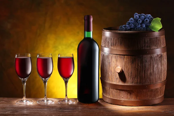Bottle and a glass of wine with a wooden barrel — Stock Photo, Image