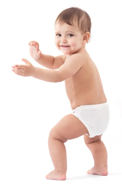 Funny baby stays near the wall. Stock Picture