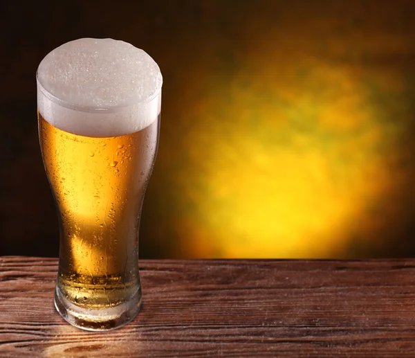 Vaso de cerveza en una mesa de madera. —  Fotos de Stock