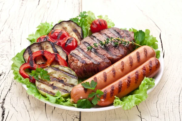 Gegrilde steak, worstjes en groenten. — Stockfoto