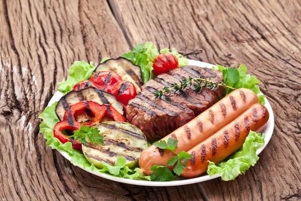 Steak grillé, saucisses et légumes . — Photo