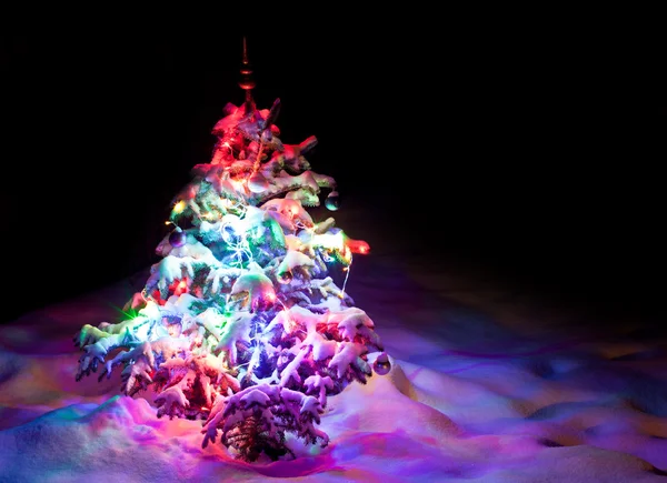 Árvore de Ano Novo luminoso abaixo da neve de pó . — Fotografia de Stock