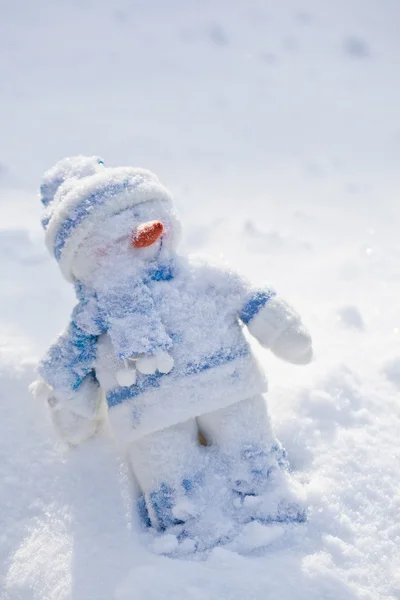 Piccolo pupazzo di neve con naso di carota nella neve . — Foto Stock