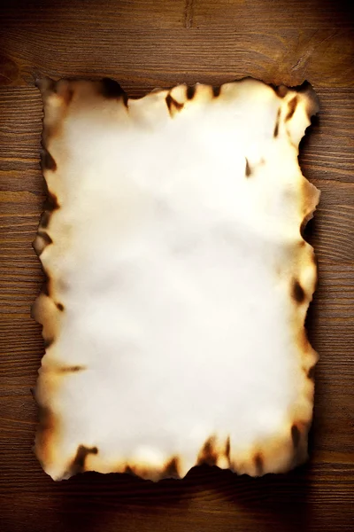 Kenarları dokulu kağıt ahşap bir duvara, yanmış — Stok fotoğraf