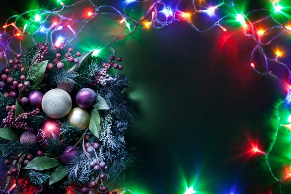 Kerstdecoratie met sparren en kerstballen en fairy lights. — Stockfoto