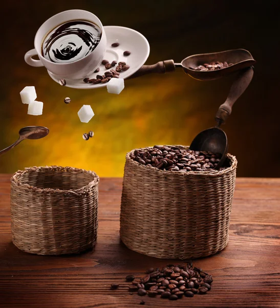 Tasse Kaffee, ein Zucker und Kaffeebohnen in der Luft . — Stockfoto