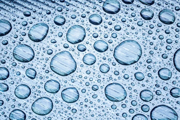 Gotas de agua sobre un fondo plástico . — Foto de Stock