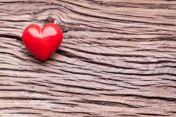 Valentines den. Červené srdce na dřevěný stůl. — Stock fotografie