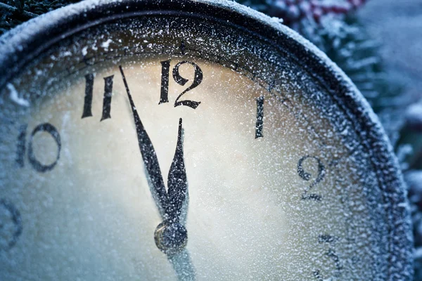 New Year clock powdered with snow. Stock Photo