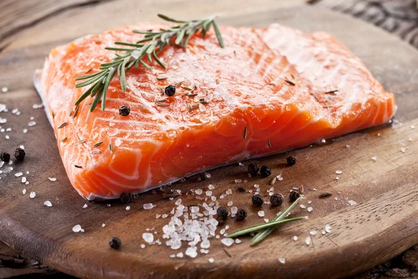 Filet de saumon sur une planche à découper en bois. — Photo