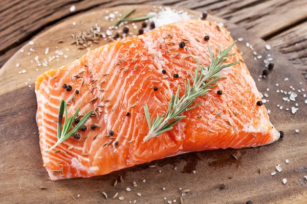 Salmon filet on a wooden carving board. — Stock Photo, Image