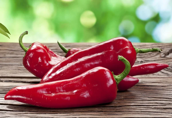 Poivrons rouges sur une table en bois . — Photo